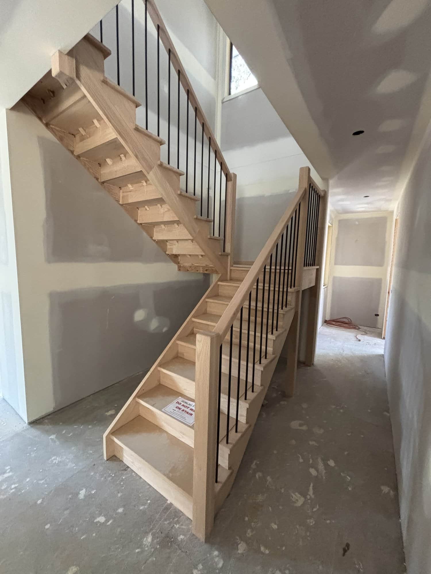 Open-riser U-flight staircase with steel rod balustrade in Beaumaris