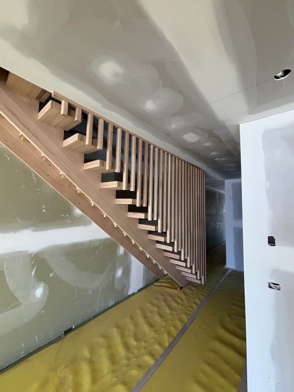 Open-riser staircase with full-height vertical timber dowel balustrade in Hampton