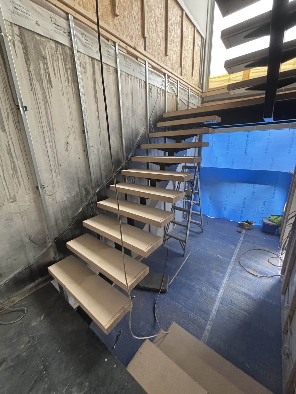 Floating open-riser staircase with cable balustrade in Hawthorn East