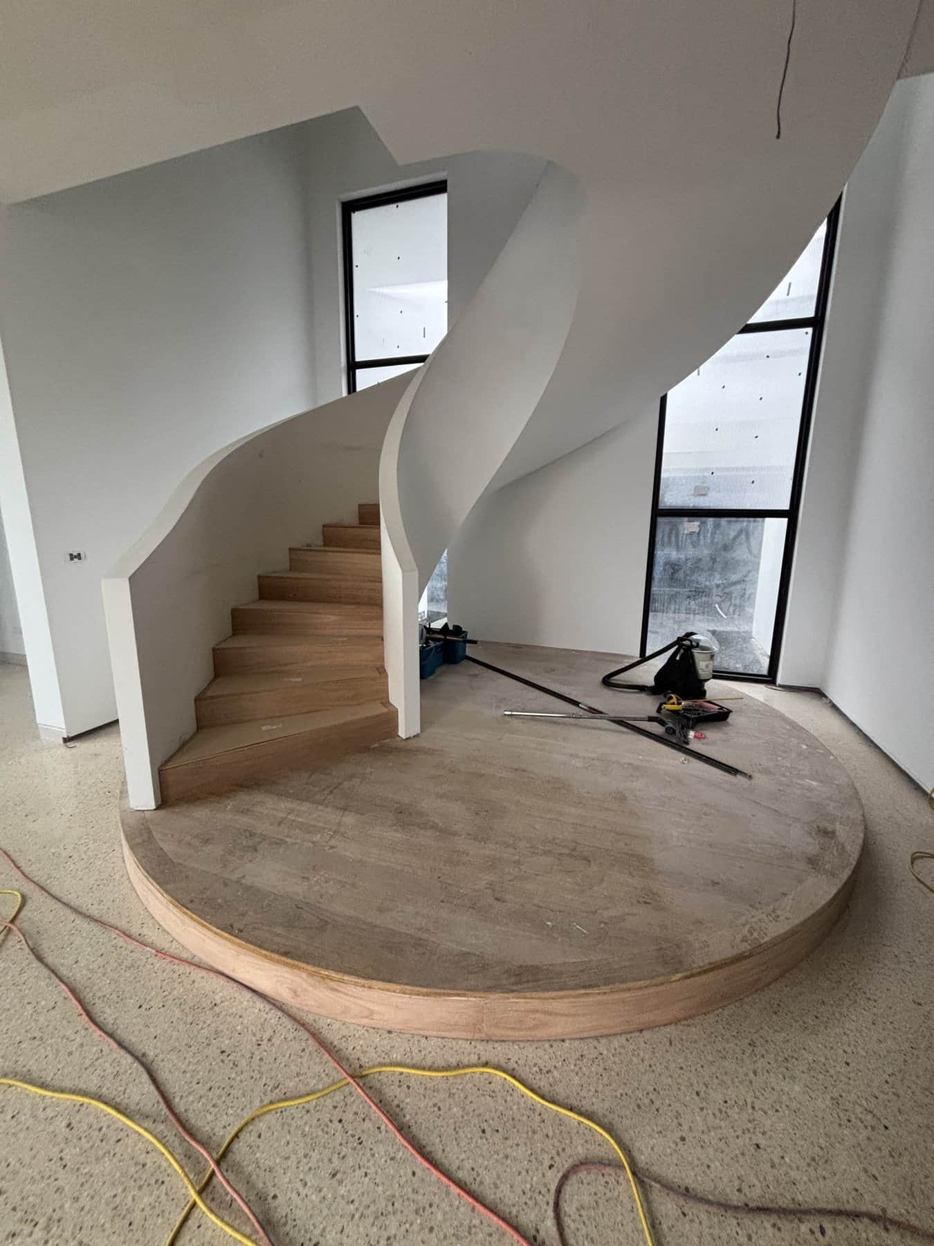 Sculptural curved staircase with circular timber landing in Mount Eliza