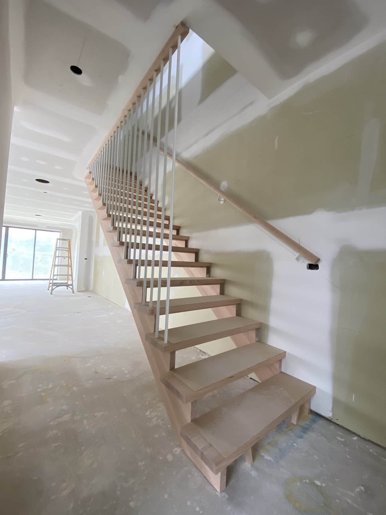 Sweeping curved staircase with white spindle balustrade in Sandringham