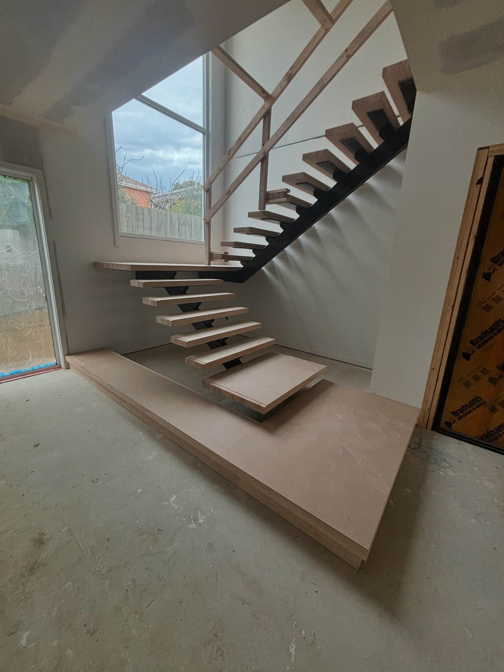 Cantilevered timber staircase against full-height glazing — a CTM Stairs new build