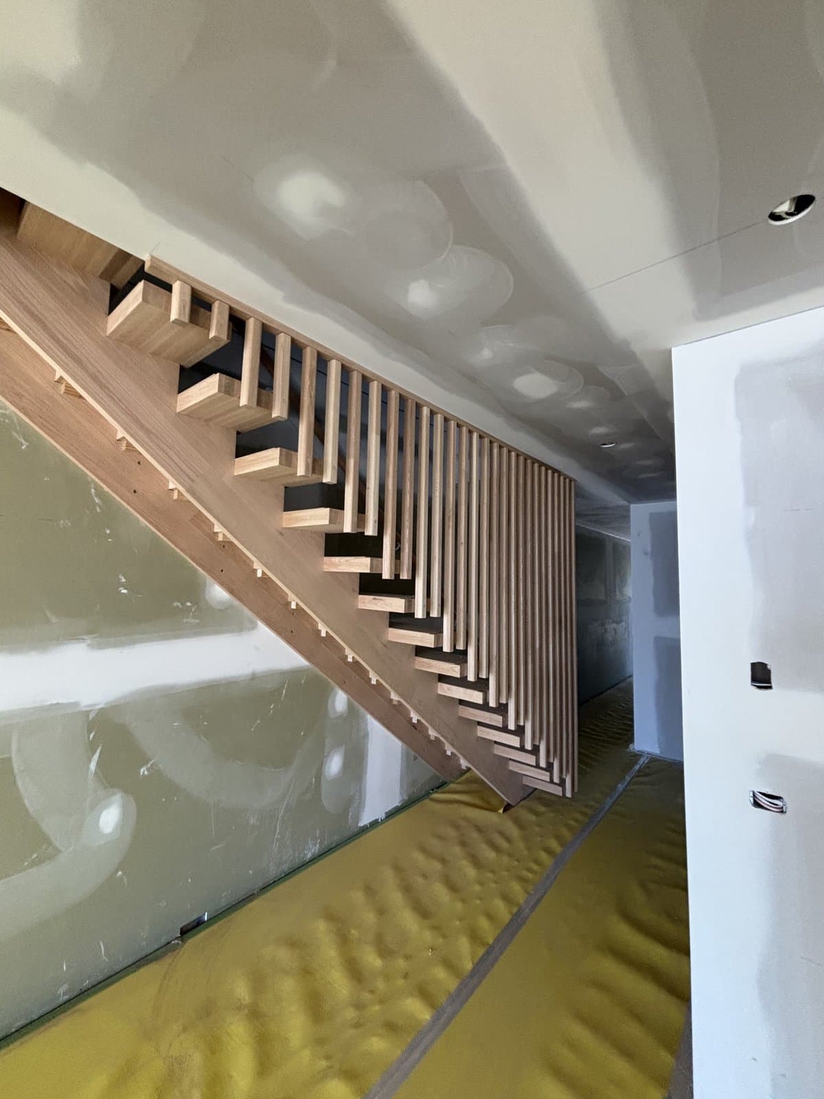 Open-riser staircase with full-height vertical timber dowel balustrade in Hampton
