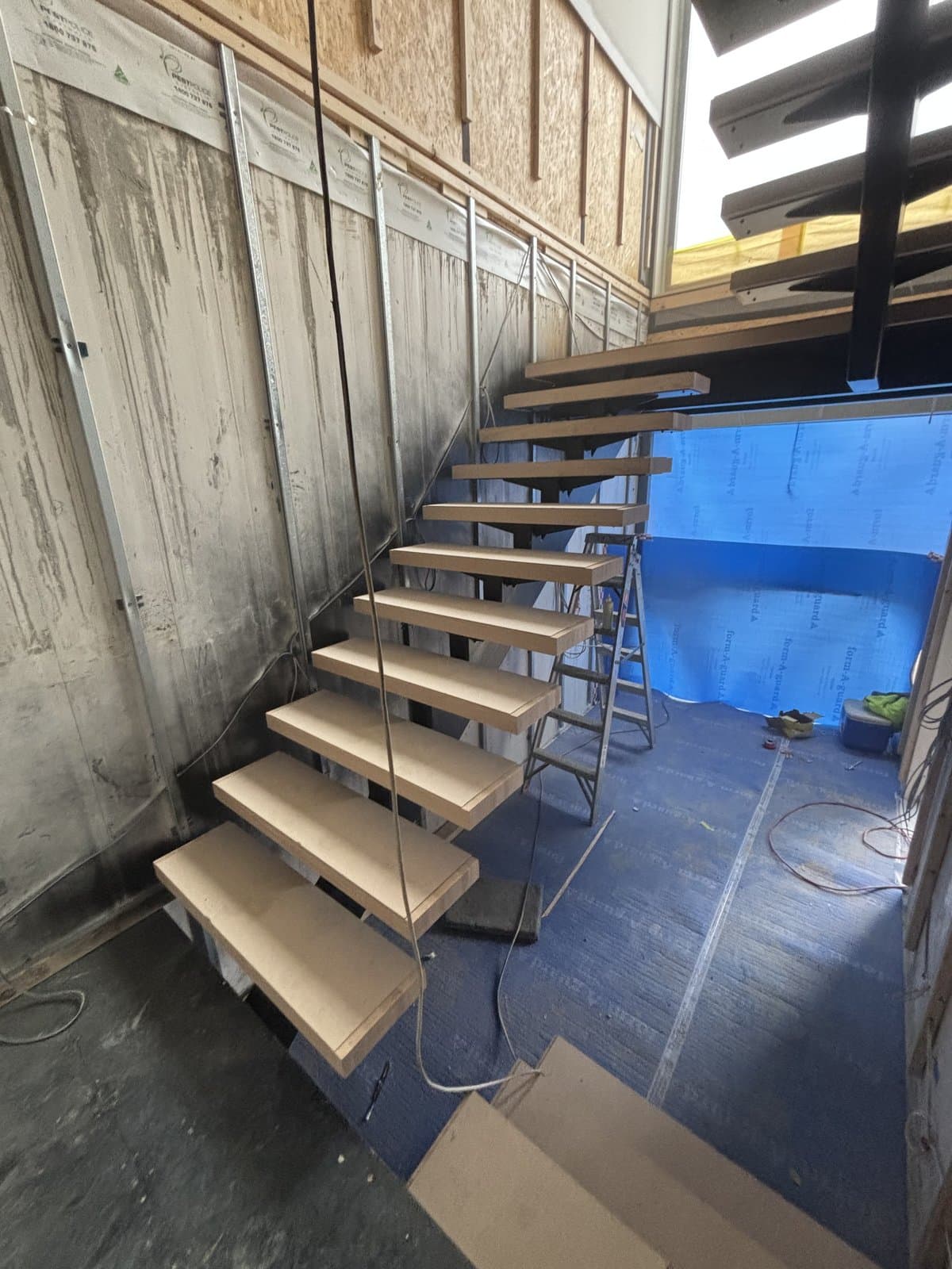 Floating open-riser staircase with cable balustrade in Hawthorn East