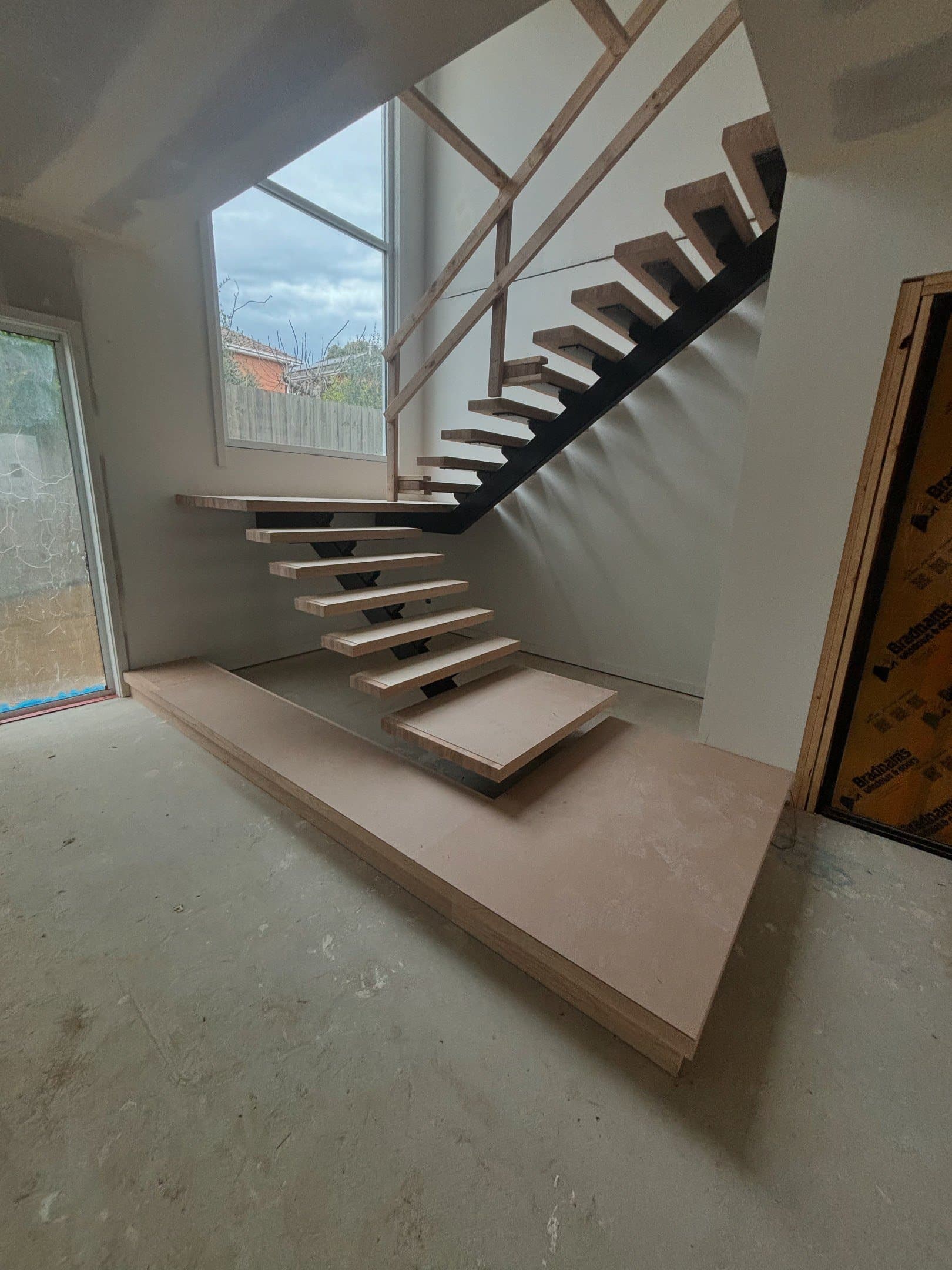 Cantilevered timber staircase against full-height glazing — a CTM Stairs new build